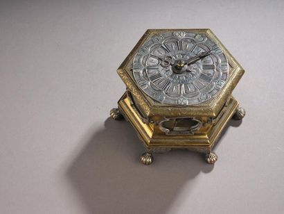 null Horloge de table hexagonale. La boîte en bronze doré et argenté ciselé repose...