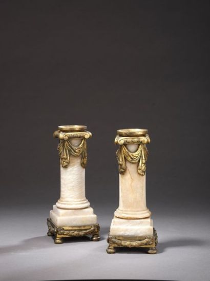 null Pair of candlesticks forming a half-column in moulded onyx, the chased and gilded...