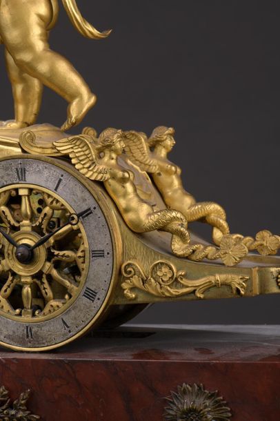 null A gilt bronze clock representing the chariot of Love pulled by a lion. The annular...
