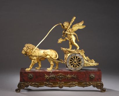null A gilt bronze clock representing the chariot of Love pulled by a lion. The annular...