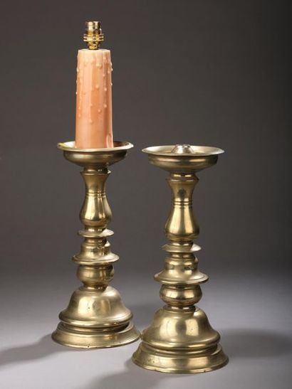 null Pair of brass candelabra, the circular moulded base, the barrel in baluster...