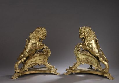  Paire de feux en bronze ciselé et doré figurant des lions menaçants debout sur une...