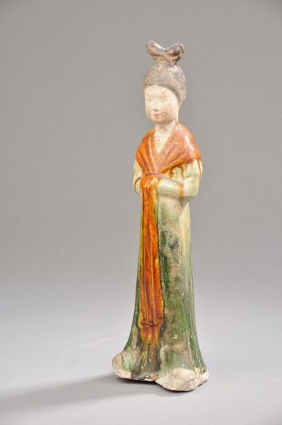 null CHINE - Époque TANG (618-907).
Statuette de femme de cour debout les mains jointes...