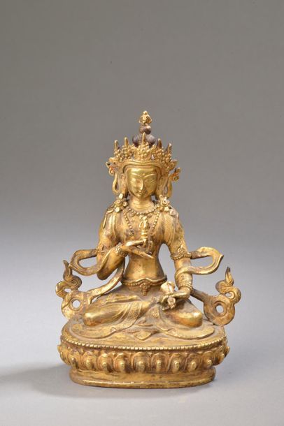 null TIBET - Début XXe siècle.
Statuette en bronze doré de Vajradhara assis en padmasana...