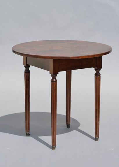 null *Table circulaire en bois naturel, le piètement cannelé et fuselé, de style...