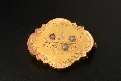 null Broche polylobée en or jaune 18k, à décor ciselé de fleurs piqué de trois demi-perles.
Fin...