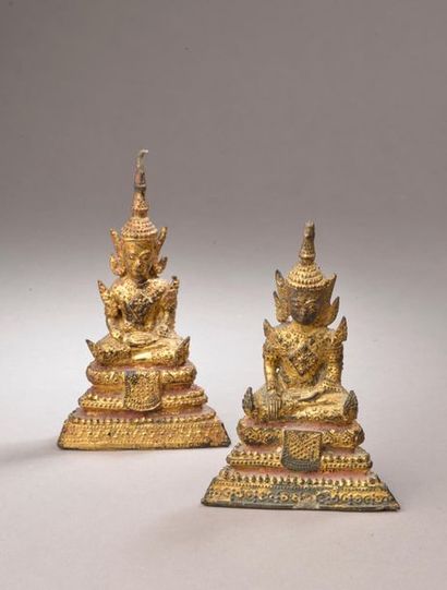 null Deux bouddhas en bronze à patine dorée richement parés et assis sur une base...