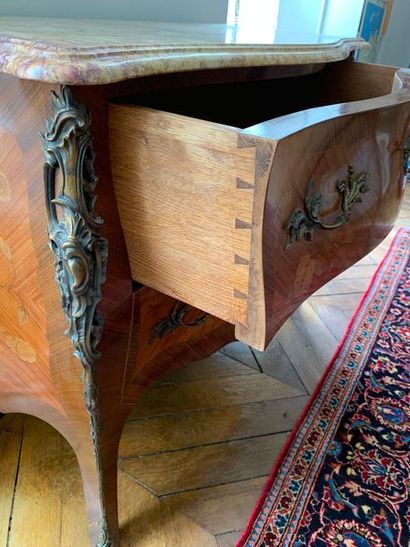 null Commode galbée, les côtés et les tiroirs marquetés de feuillages fleuris. Elle...