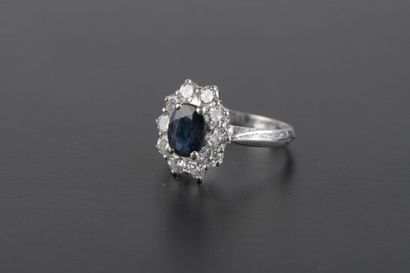 null Bague marguerite en or gris 18k griffée d'un saphir bleu foncé dans un entourage...