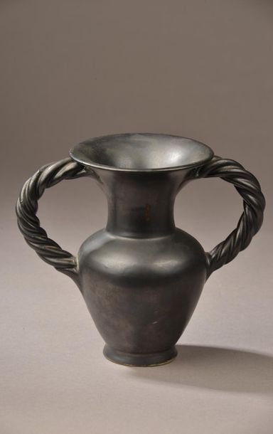 null VALLAURIS, XXe siècle.
Vase à deux anses torsadées en faience à lustre noir.
Marque...