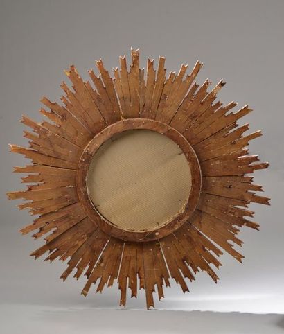 null Miroir circulaire en bois sculpté et doré à décor rayonnant (accidents et manques).
Travail...