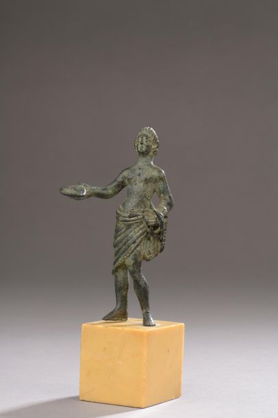 null Statuette représentant un dieu Lare au torse nu tenant une phiale dans sa main...