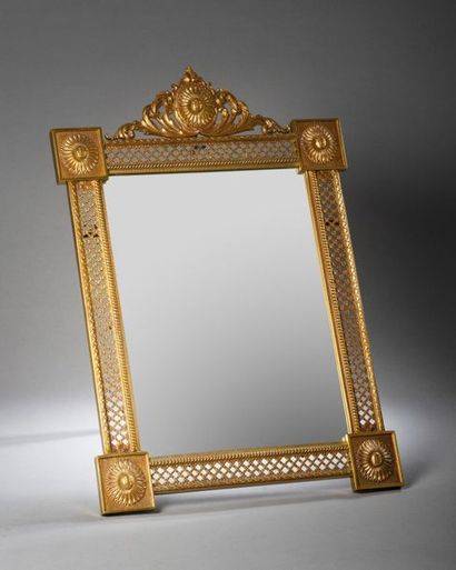 null Miroir à fronton en bronze doré, la bordure ajourée à décor de treillage et...