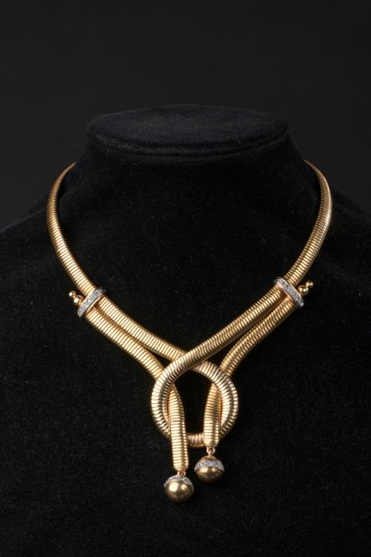 null Collier en or jaune 18k à maille tubogaz centré d'un nœud retenant deux brins...