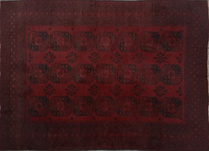 null Tapis en laine sur fond rouge à trois rangées de sept gül et motifs étoilés...