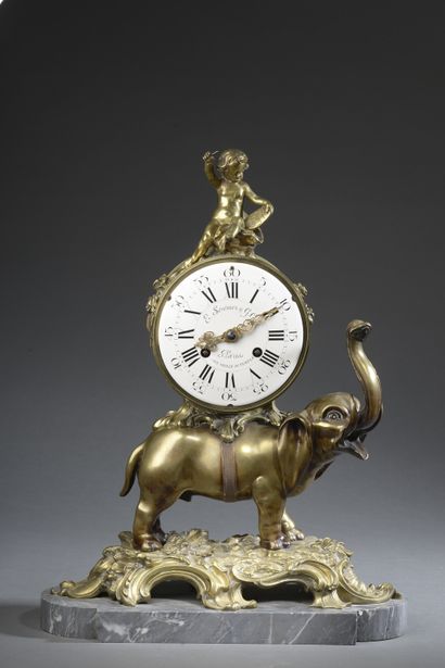 null Bronze elephant clock with golden patina resting on a grey St. Anne marble base....