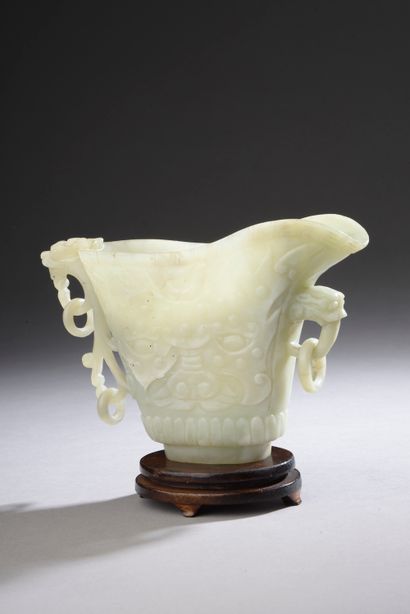 null CHINA - 19th century.

A jadeite coffee pot with flattened carved taotie masks,...