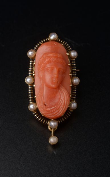 An 18k yellow gold brooch with a coral cameo...