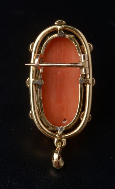 null An 18k yellow gold brooch with a coral cameo carved with a three-quarter bust...