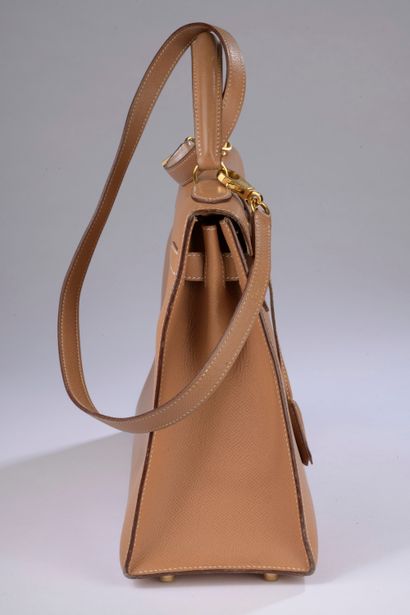null HERMÈS.

Kelly" 32 cm bag in Courchevel gold leather with white saddle stitching,...