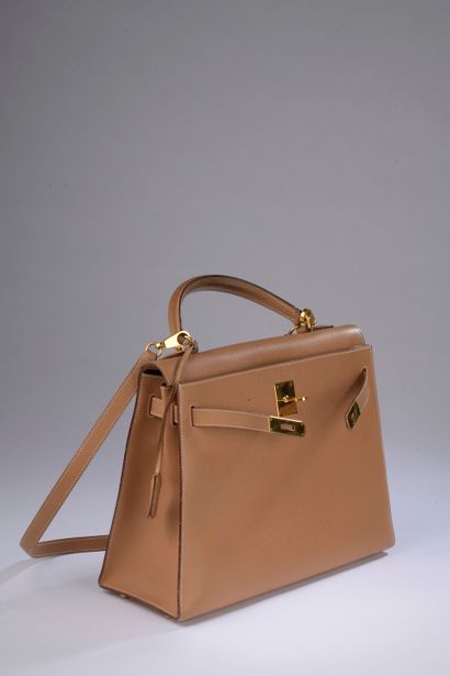 null HERMÈS.

Kelly" 32 cm bag in Courchevel gold leather with white saddle stitching,...