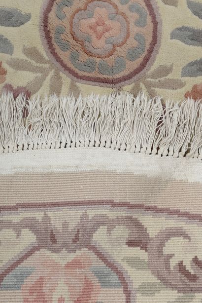 null Tapis circulaire en laine et coton à décor polychrome de fleurs sur fond beige.

Chine,...