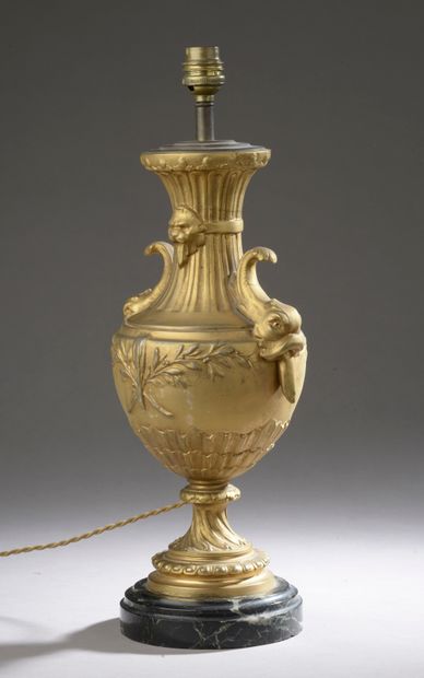 null A gilded regule lamp, the body decorated with foliage, the handles in the shape...