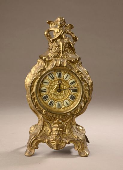 null A gilt bronze clock surmounted by a putto, the dial stamped with cherubs and...