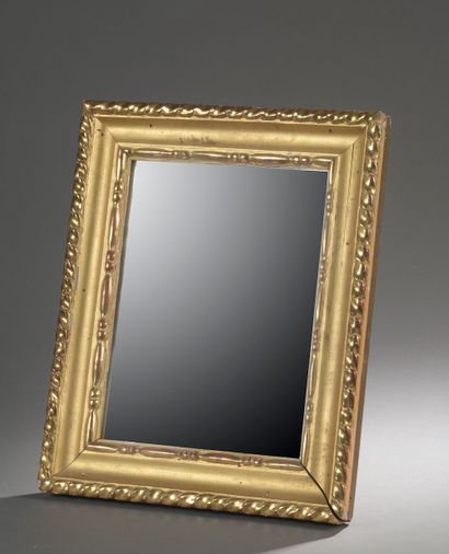 null A small rectangular bevelled mirror, the frame in wood and gilded composition...
