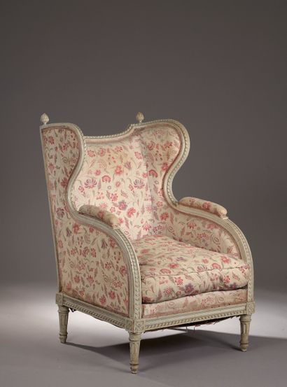  A moulded, carved and grey lacquered wood wing chair, the concave back decorated...