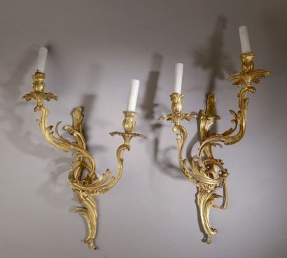 null A large pair of chased and gilt bronze sconces with two sinuous foliated arms...