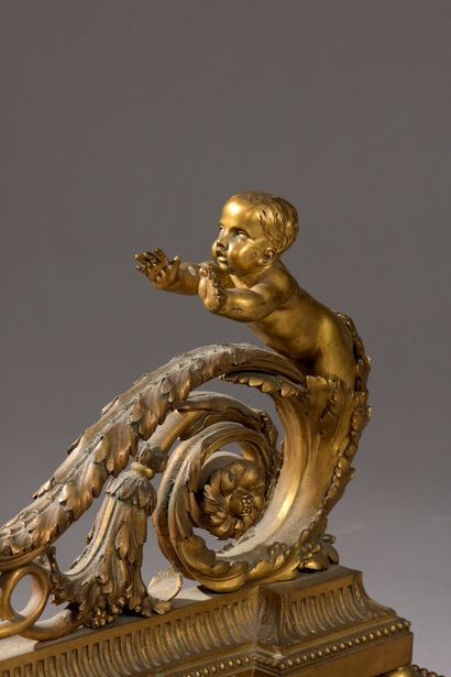  Pair of chased and gilded bronze andirons representing a child on an acanthus scroll,...