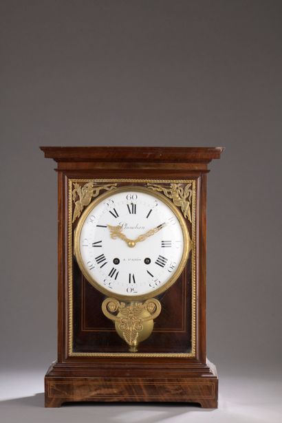 null A mahogany, mahogany veneer and light wood fillet cage clock with a large round...