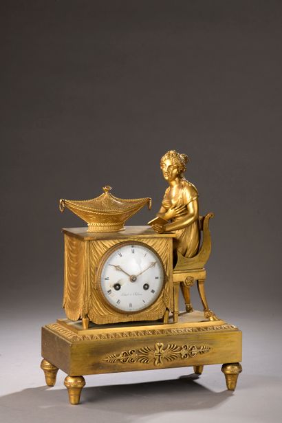 null Chased and gilt bronze clock, the dial inscribed in a table on which a young...