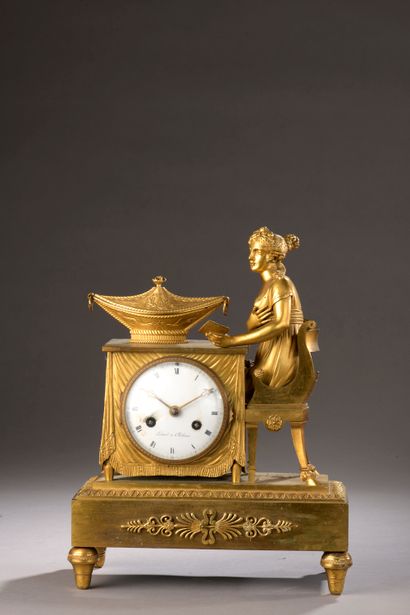 null Chased and gilt bronze clock, the dial inscribed in a table on which a young...