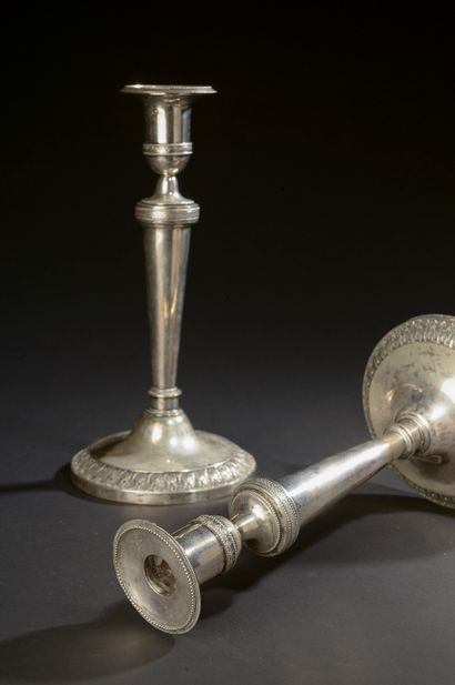 null Pair of silver torches with repoussé decoration of foliage, pearls and crosses.

Belgium,...