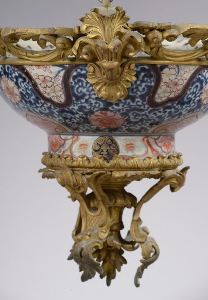  A Japanese porcelain punch bowl with Imari decoration and a rich gilt bronze frame...