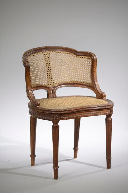 null A beechwood caned desk armchair, the violin back carved with foliated friezes...