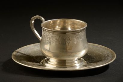 null *Tasse à déjeuner et sa sous-tasse en argent à décor gravé d'une frise feuillagée.

Vers...