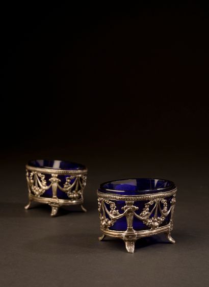 null Pair of silver salverons with openwork decoration of festoons. Blue tinted glass...