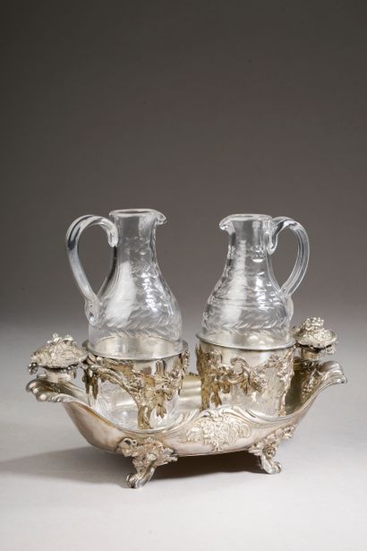 null A silver navette-shaped oil and vinegar cruet, the openwork cups finely chiselled...