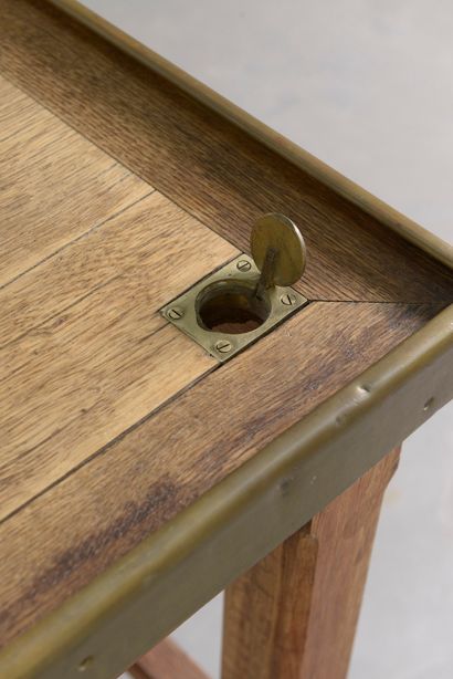 null A large moulded oak changer's table with a rectangular top surrounded by a brass...