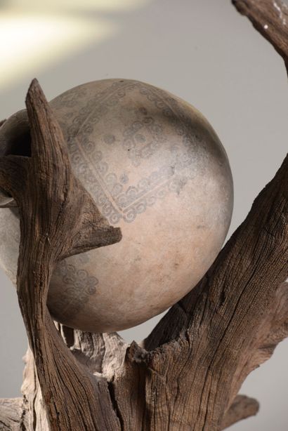  Sculpture remployant un arbre en bois flotté soutenant une jarre en céramique éthiopienne....
