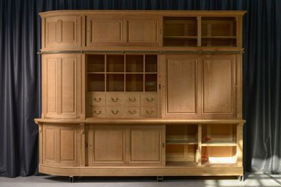 null A large moulded oak corner cabinet opening with six sliding doors and three...