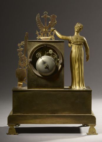 null Pendule en bronze doré décorée d'une femme vêtue à l'antique tenant une lampe...