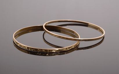 null Set of two 18k yellow gold bracelets, one engraved with a floral motif, the...