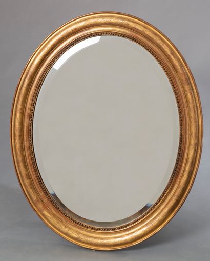 null Miroir ovale en bois et composition dorée à décor d'une frise de perles et fleurs...