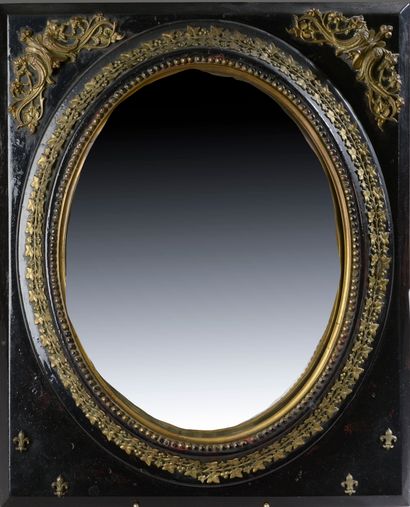 null Miroir sorcière ovale dans un cadre en bois laqué noir cerné d'un décor doré...