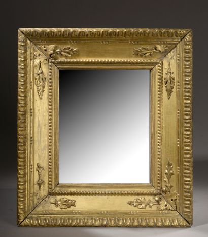 null Miroir rectangulaire formé par un cadre en bois sculpté et doré, les angles...