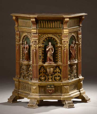  Trapezoidal piece of furniture in carved and gilded wood, the three faces with niche...